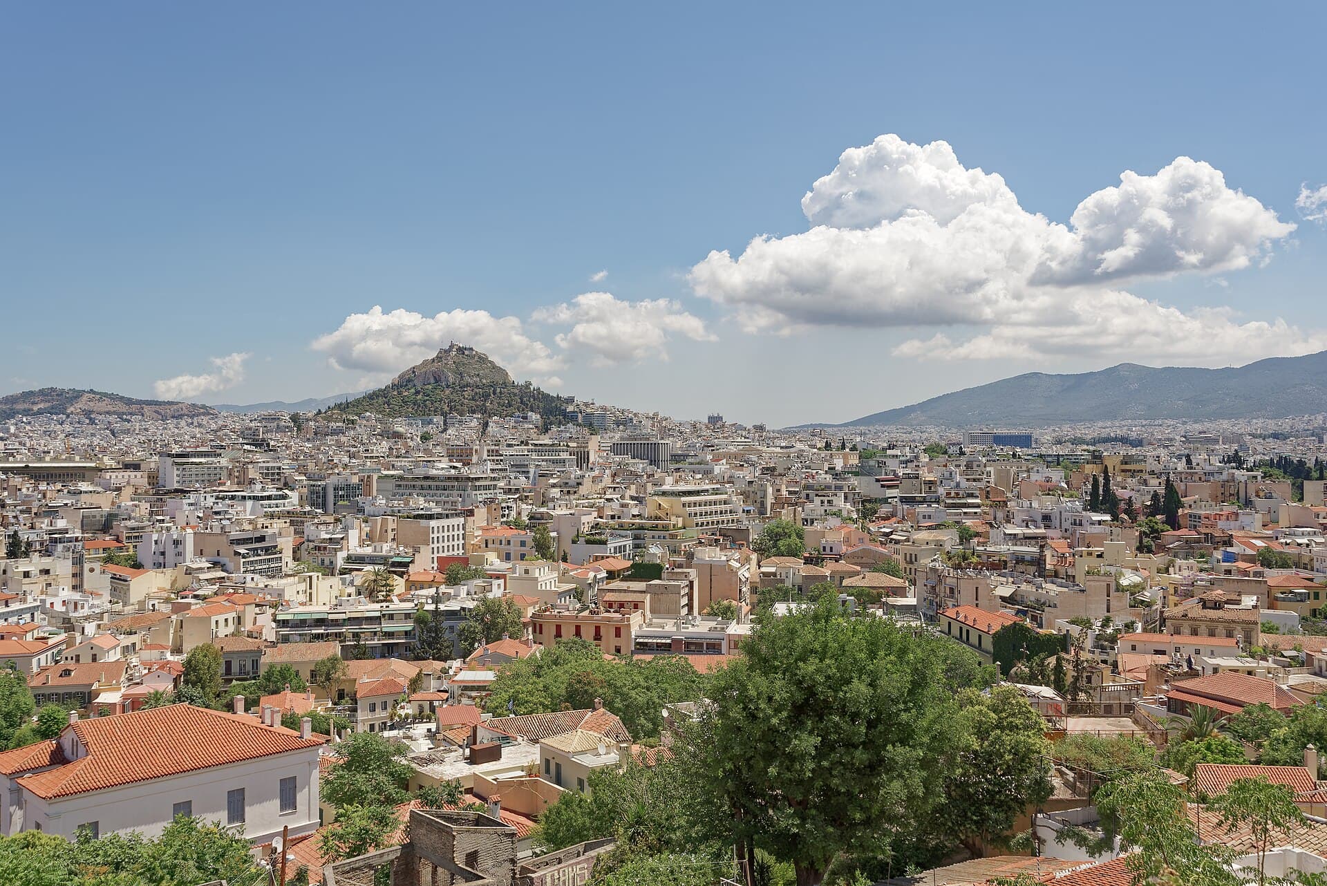 Dalle pendici dell'Acropoli, sopra il microquartiere cicladico di Anafiotika, lo sguardo corre sui tetti di Atene fino al colle del Licabetto.