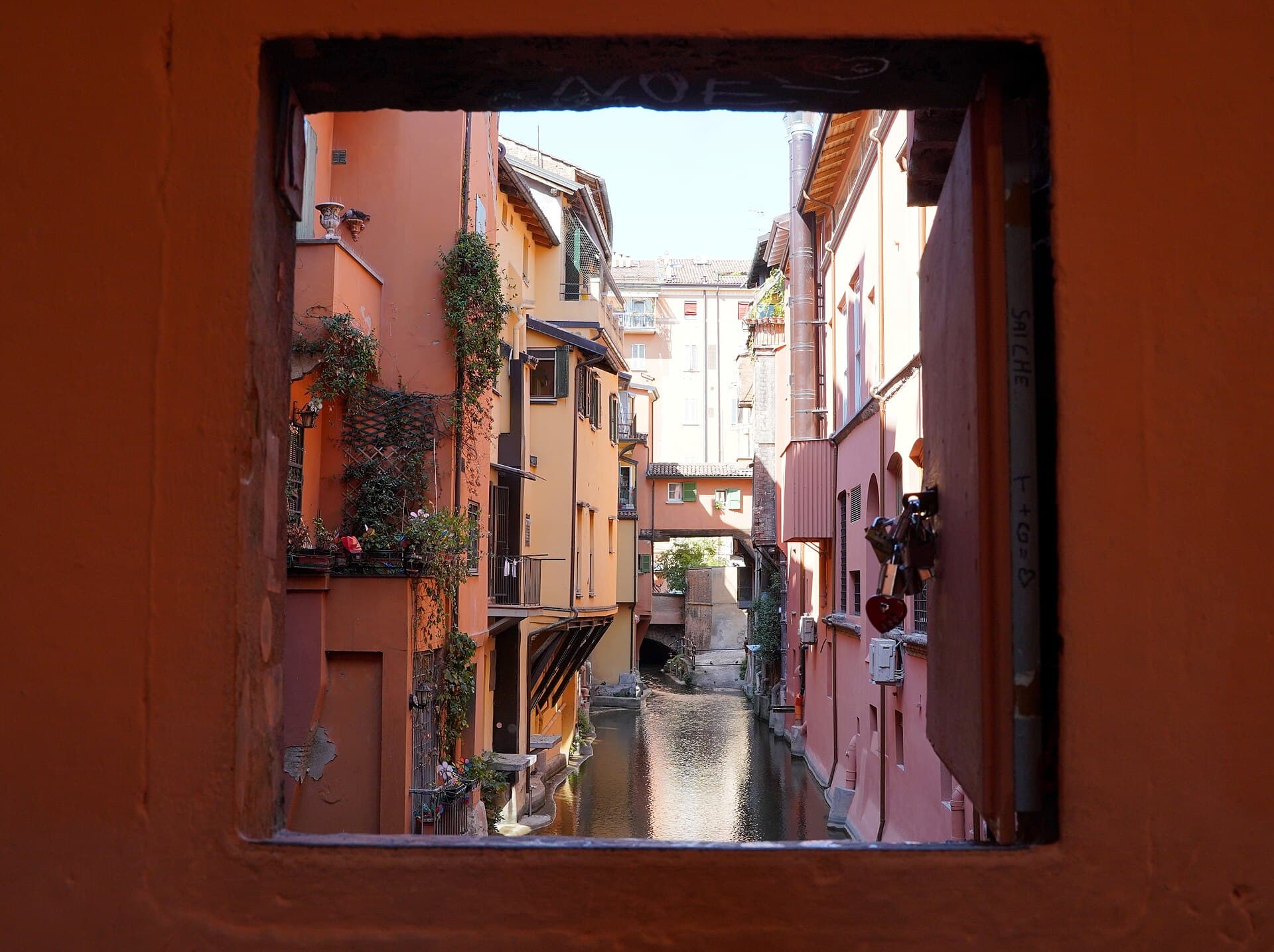 La Finestrella di Via Piella: una piccola apertura nel muro svela un canale nascosto, la 'piccola Venezia' di Bologna sopravvissuta sotto le strade.