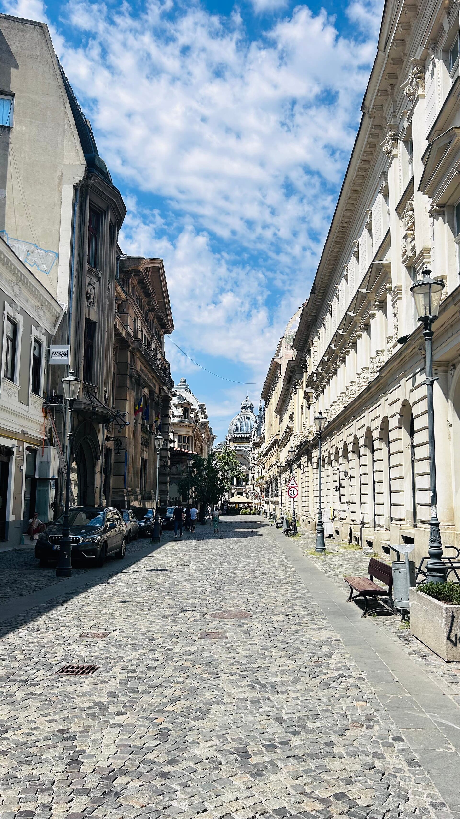 A cobbled street in the Old Town with the dome of the CEC Palace behind.