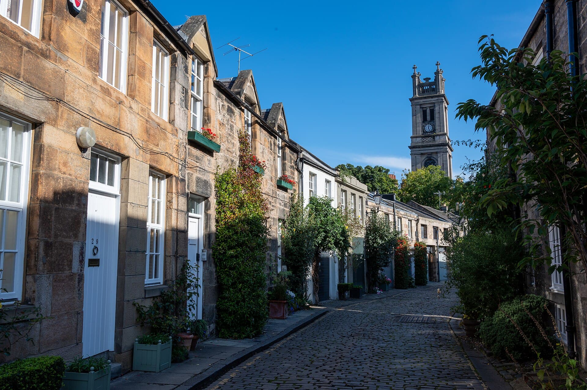 Circus Lane, a Stockbridge: un vicolo acciottolato fiancheggiato da antiche rimesse e giardini fioriti, una delle vie più suggestive e nascoste di Edimburgo.