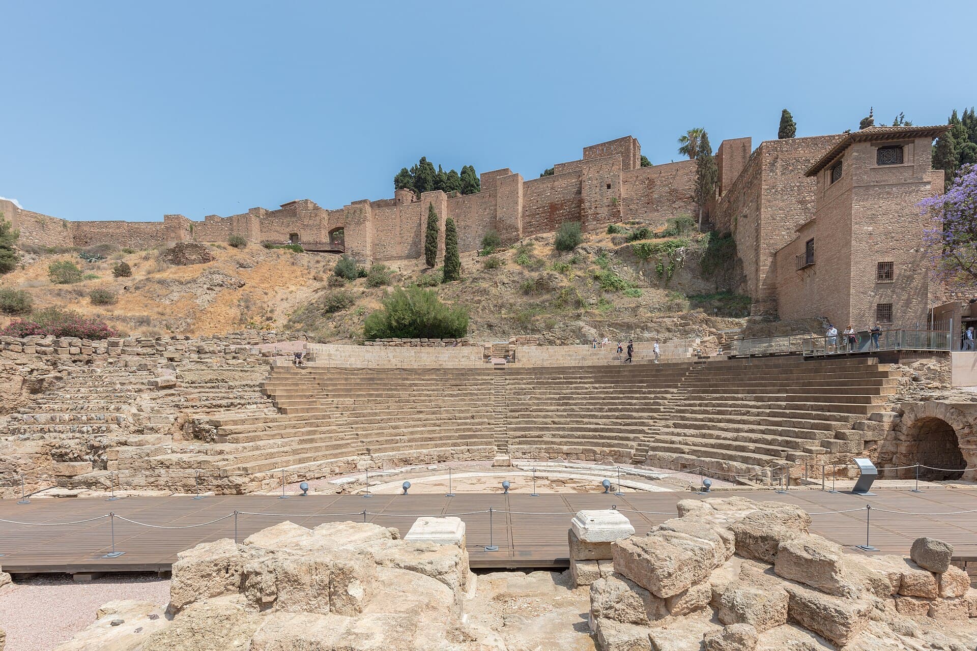 Il Teatro Romano ai piedi dell'Alcazaba: l'antica cavea riportata alla luce nel cuore della città, con la fortezza moresca che si arrampica sulla collina.